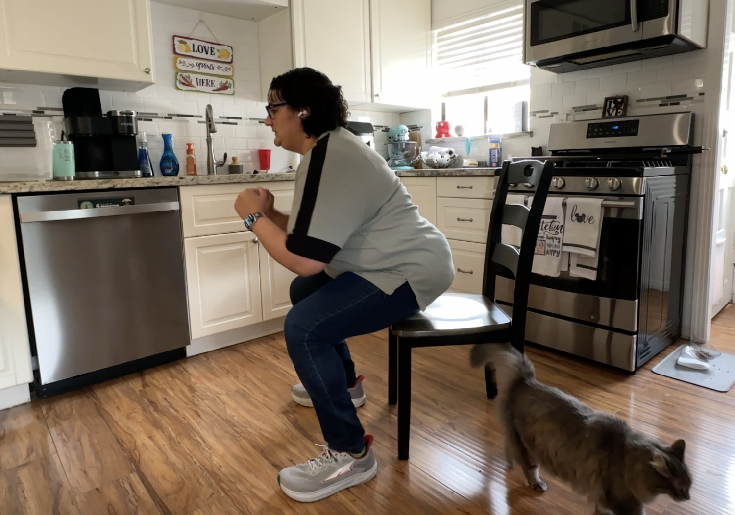 Woman standing up from dining room chair in kitchen